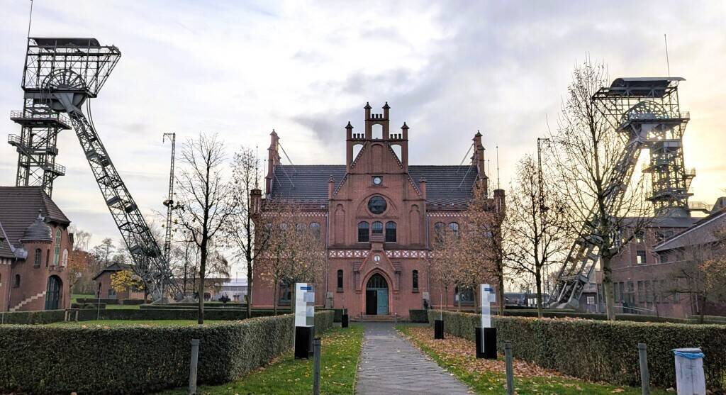 Blick über die Mittelachse des Geländes auf das Verwaltungsgebäude und die beiden Fördergerüste 2 und 4