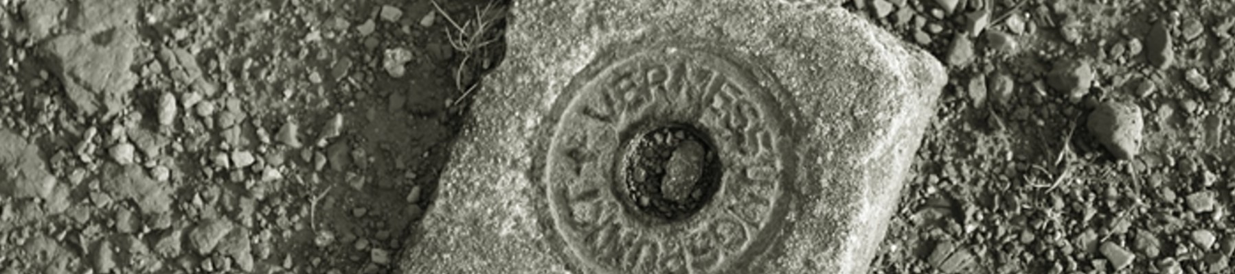 Vermessungspunktstein auf losem Geröll